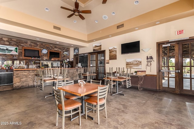 dining area with concrete floors, visible vents, and french doors