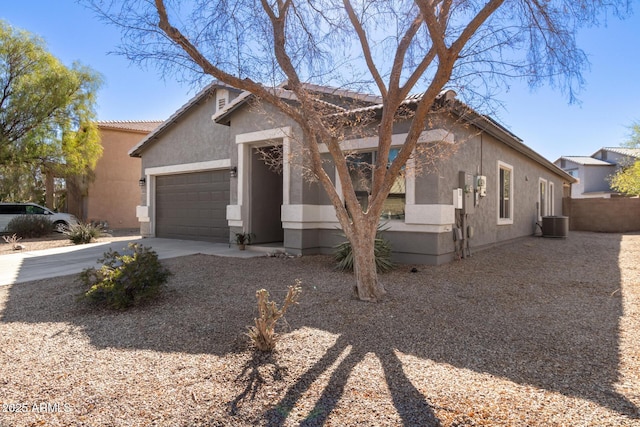 view of front of property with driveway, central AC, an attached garage, and stucco siding