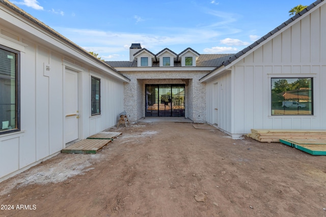 view of exterior entry with a patio