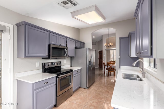 kitchen with stainless steel appliances, vaulted ceiling, sink, decorative light fixtures, and a notable chandelier