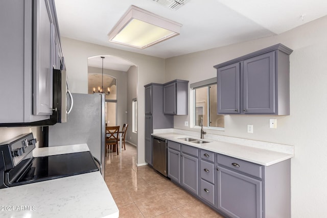 kitchen with sink, stainless steel appliances, a notable chandelier, pendant lighting, and light tile patterned floors