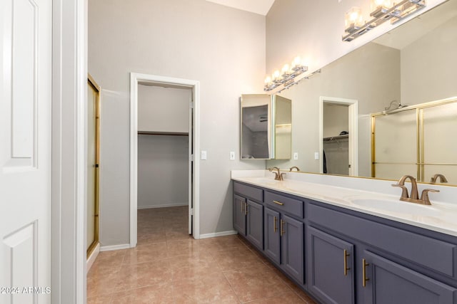 bathroom featuring tile patterned flooring, vanity, and a shower with shower door