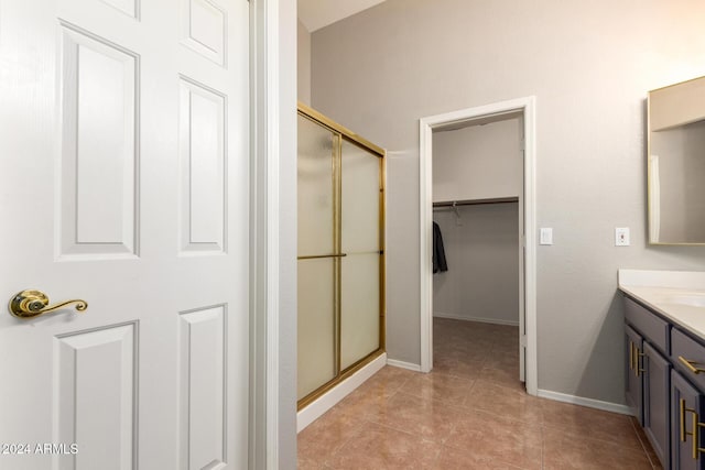 bathroom featuring tile patterned flooring, vanity, and walk in shower