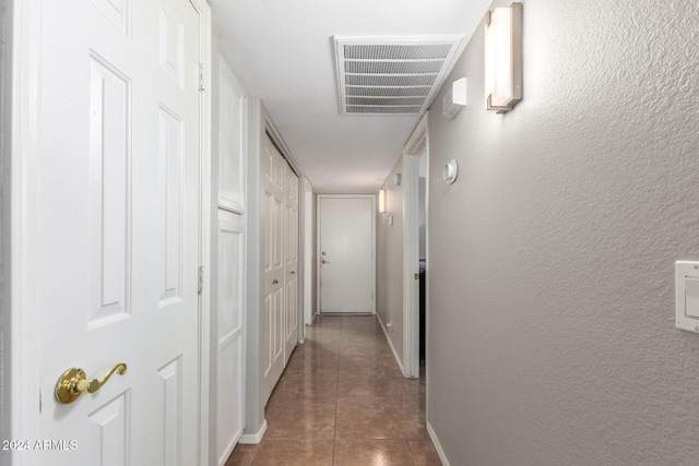 hall featuring dark tile patterned floors