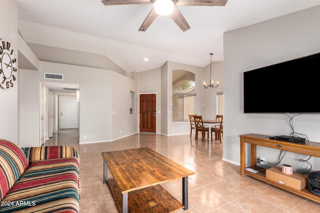 living room with ceiling fan with notable chandelier, lofted ceiling, and light tile patterned flooring