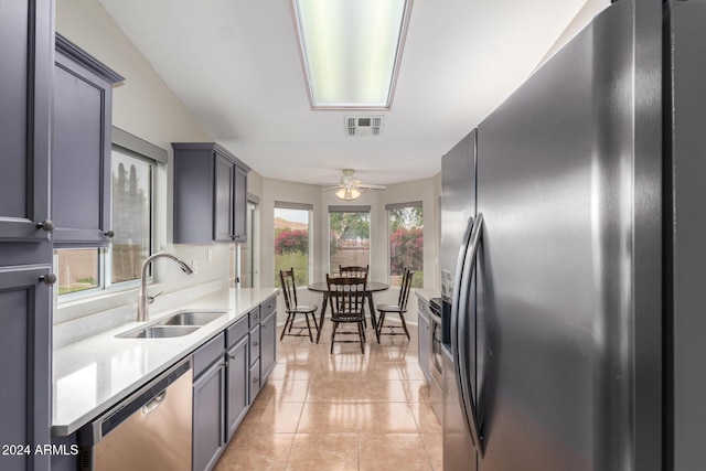 kitchen with ceiling fan, light tile patterned flooring, sink, and stainless steel appliances