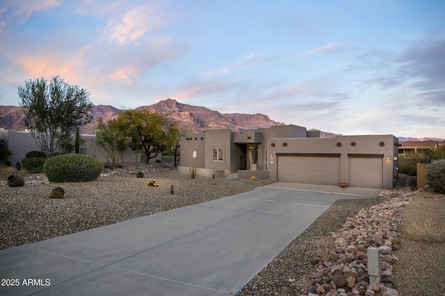 adobe home featuring a mountain view and a garage