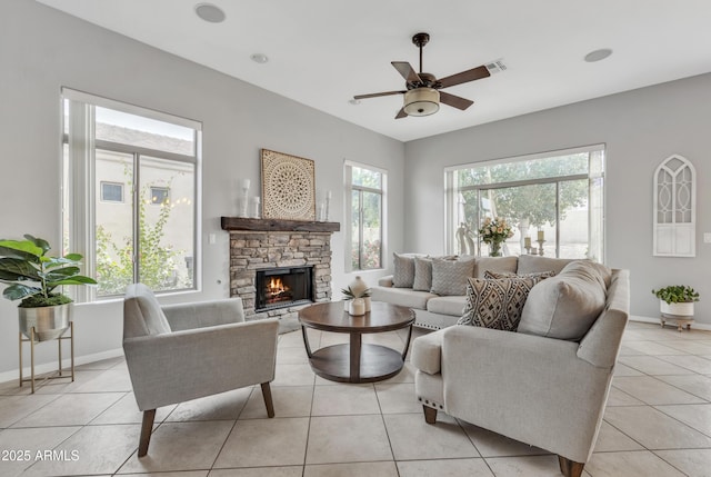 tiled living room with ceiling fan and a fireplace