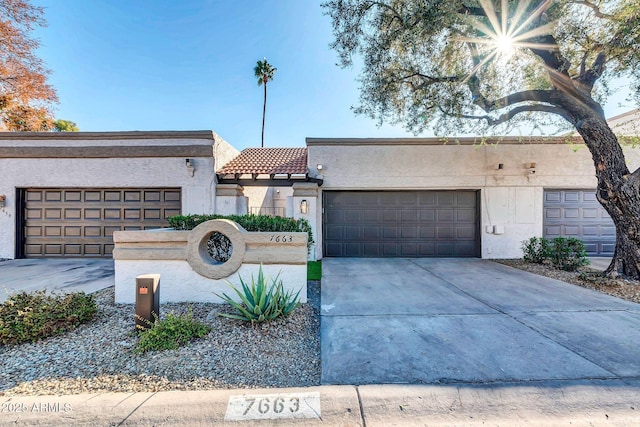 view of front of house with stucco siding, concrete driveway, and a tiled roof