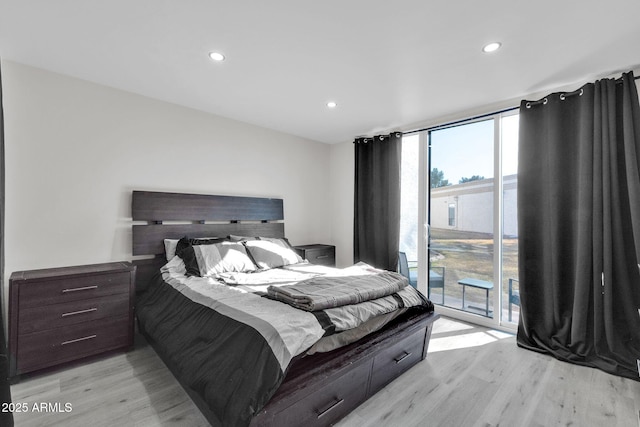 bedroom with a wall of windows, light wood-style floors, recessed lighting, and access to outside