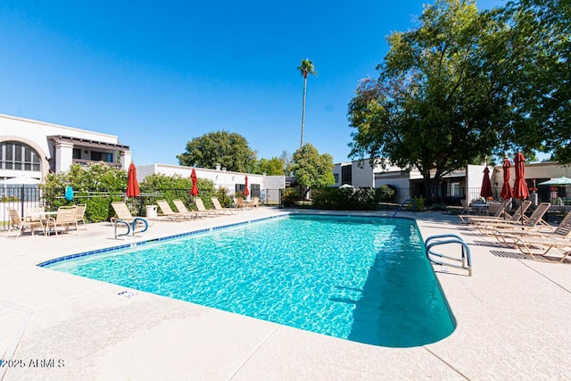 community pool featuring a patio area and fence