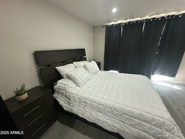 bedroom with lofted ceiling and wood finished floors