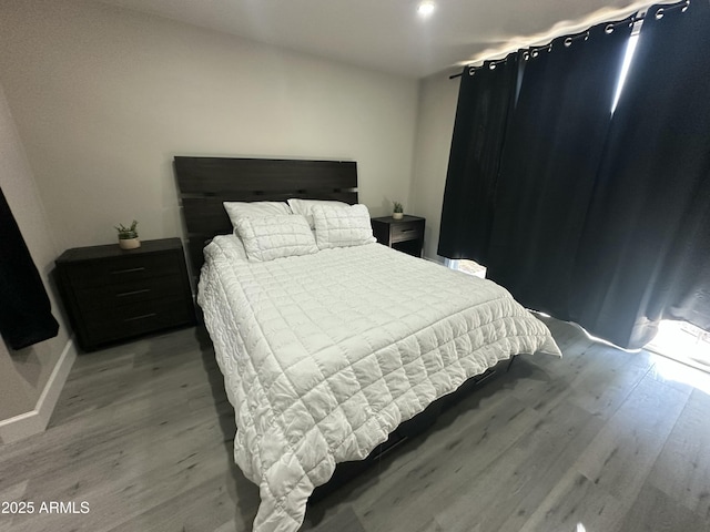 bedroom with wood finished floors and baseboards