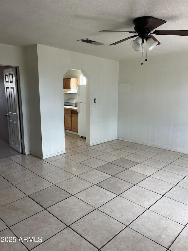 527 S Macdonald, Mesa, AZ 85210 - empty room featuring a textured ceiling, arched walkways, ceiling fan, baseboards, and light tile patterned floors