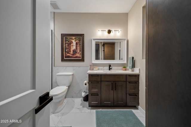 1500 W Pinetree Ct, Show Low, AZ 85901 - bathroom featuring vanity, marble look tile flooring, tile walls, and wainscoting