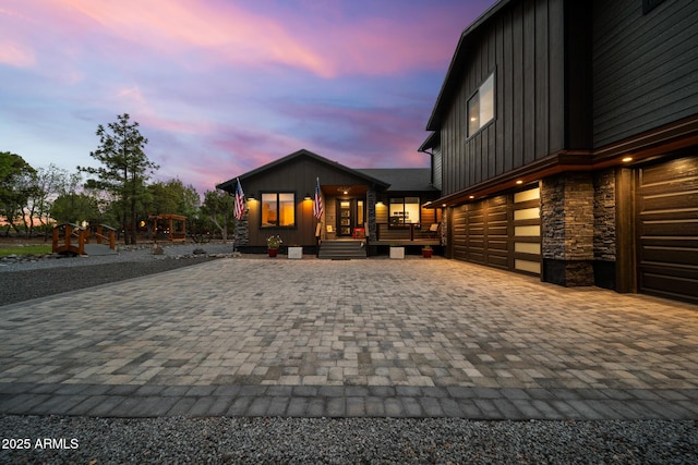 1500 W Pinetree Ct, Show Low, AZ 85901 - view of front facade featuring board and batten siding, decorative driveway, stone siding, a porch, and a garage