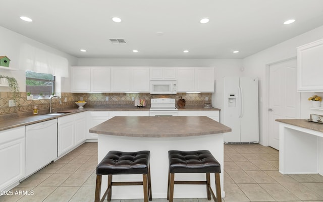 1821 E Patrick Ln, Phoenix, AZ 85024 - kitchen with white appliances, a sink, light tile patterned floors, a breakfast bar, and recessed lighting