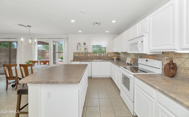 1821 E Patrick Ln, Phoenix, AZ 85024 - kitchen featuring white appliances, light tile patterned flooring, healthy amount of natural light, a breakfast bar area, and recessed lighting