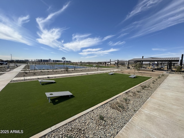 view of community featuring a lawn and fence