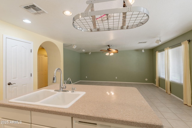 3665 E Thames Way, San Tan Valley, AZ 85140 - kitchen with a sink, light tile patterned flooring, arched walkways, a ceiling fan, and baseboards