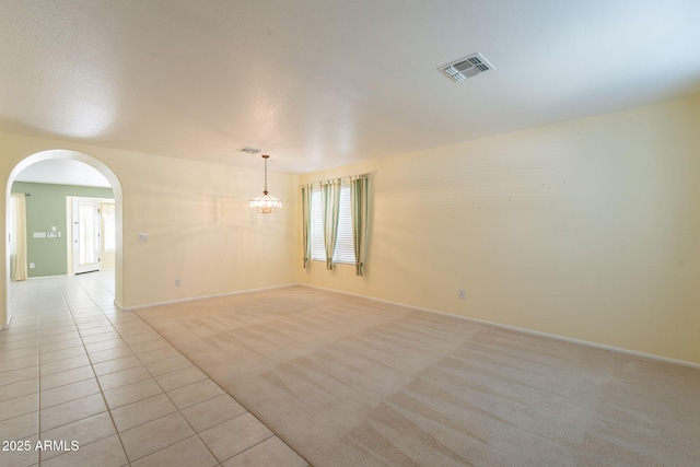 3665 E Thames Way, San Tan Valley, AZ 85140 - empty room with arched walkways, baseboards, light tile patterned flooring, and light colored carpet