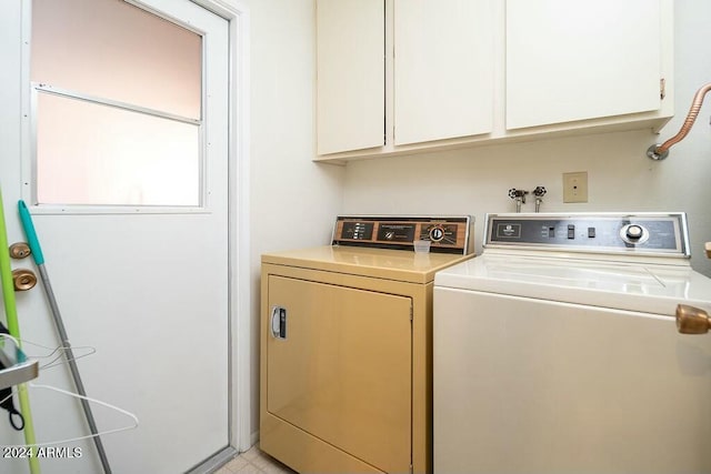 washroom with separate washer and dryer and cabinets