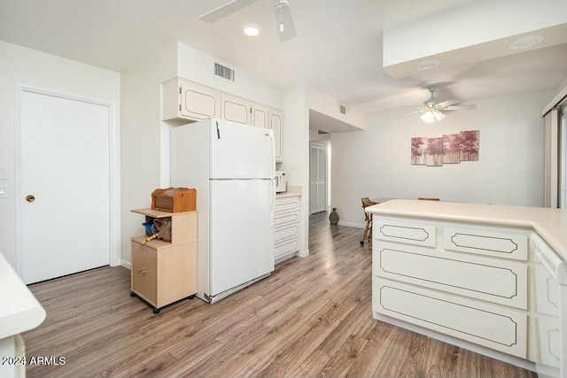 kitchen with light wood-type flooring, white appliances, white cabinets, and ceiling fan