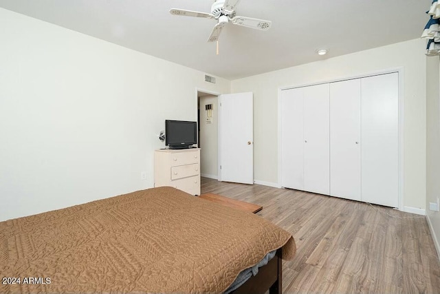 unfurnished bedroom featuring ceiling fan, a closet, and light hardwood / wood-style flooring