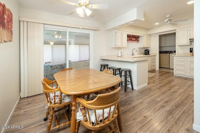 dining space with independent washer and dryer, light hardwood / wood-style flooring, and ceiling fan