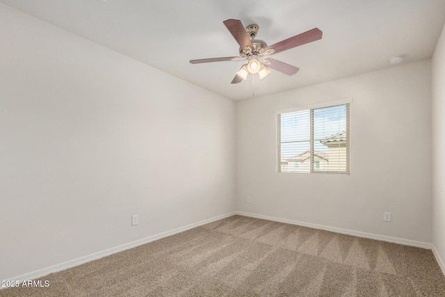 spare room featuring light colored carpet, baseboards, and ceiling fan