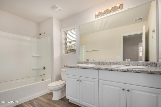 bathroom featuring a sink, visible vents, toilet, and wood finished floors