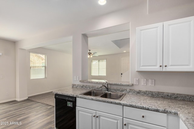 kitchen with light wood-type flooring, light countertops, black dishwasher, white cabinets, and a sink