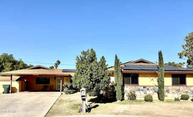 ranch-style home with a carport and solar panels