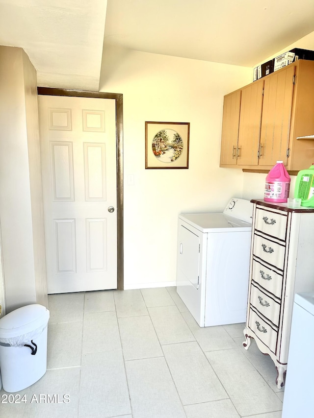 washroom featuring washer / clothes dryer, light tile patterned floors, and cabinets