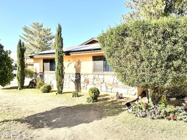 view of front of house featuring solar panels and a front lawn