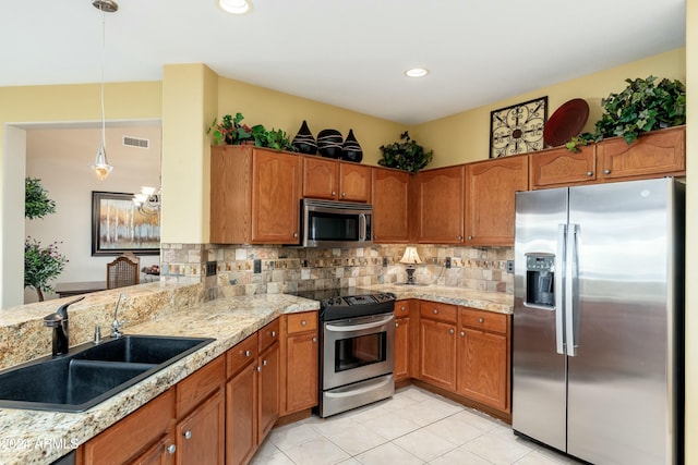 kitchen with backsplash, sink, decorative light fixtures, and appliances with stainless steel finishes