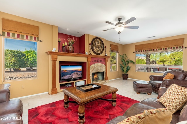 tiled living room with ceiling fan and a premium fireplace