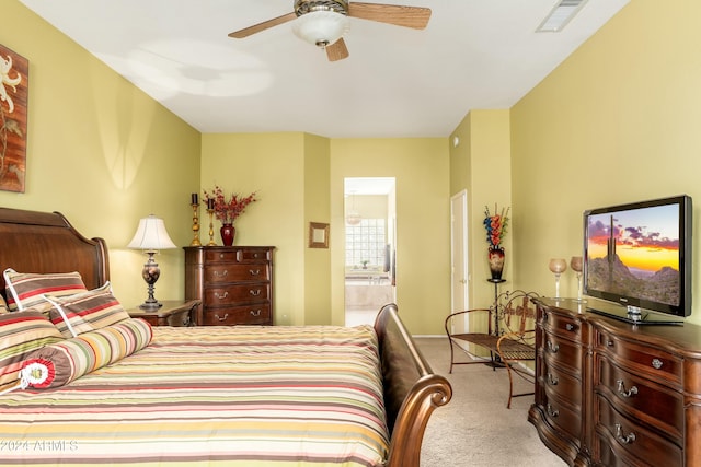 bedroom featuring light colored carpet, ensuite bath, and ceiling fan