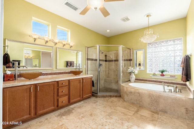 bathroom with ceiling fan with notable chandelier, vanity, and separate shower and tub