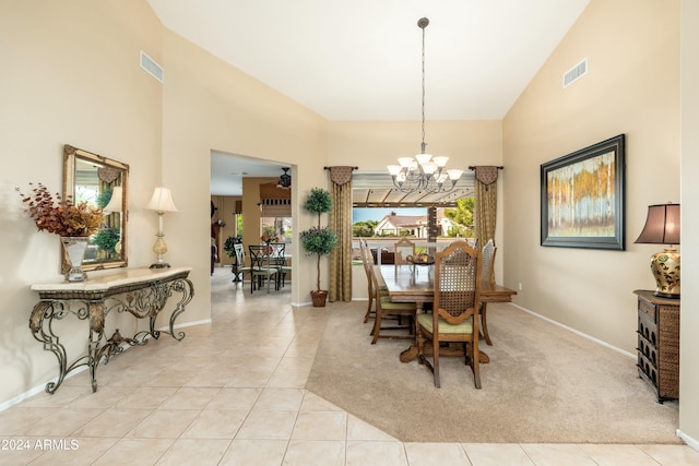 tiled dining room with high vaulted ceiling and an inviting chandelier