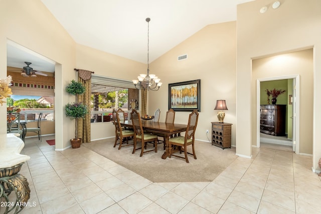 carpeted dining area with high vaulted ceiling and ceiling fan with notable chandelier