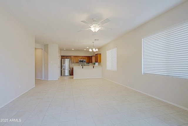 unfurnished living room featuring ceiling fan with notable chandelier and light tile patterned floors