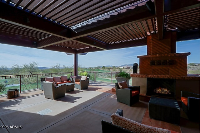 view of patio / terrace featuring a mountain view, a pergola, and an outdoor living space with a fireplace