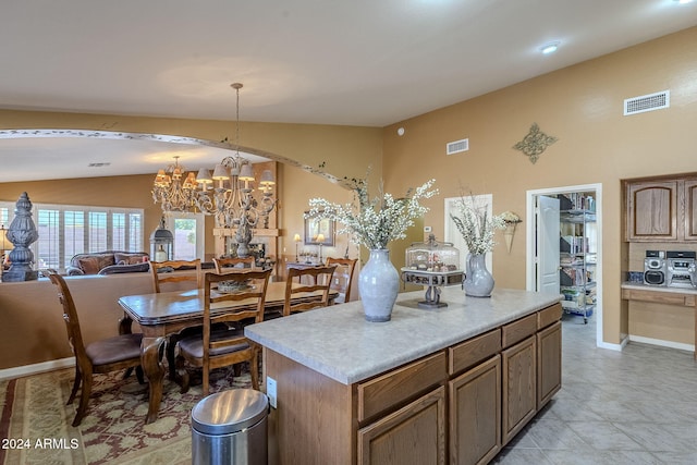 kitchen featuring an inviting chandelier, lofted ceiling, decorative light fixtures, and a center island