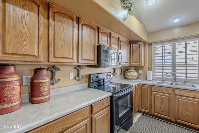 kitchen with a healthy amount of sunlight, black range with electric cooktop, sink, and light tile patterned floors