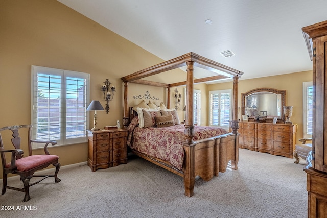 carpeted bedroom with multiple windows and vaulted ceiling