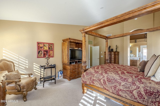 carpeted bedroom featuring connected bathroom and lofted ceiling