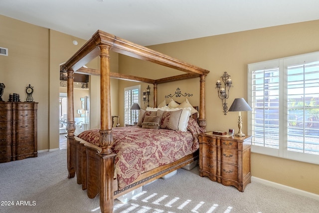 bedroom featuring light carpet and multiple windows