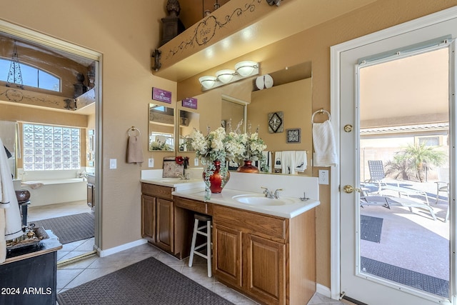 bathroom with tile patterned flooring, vanity, and a bathing tub