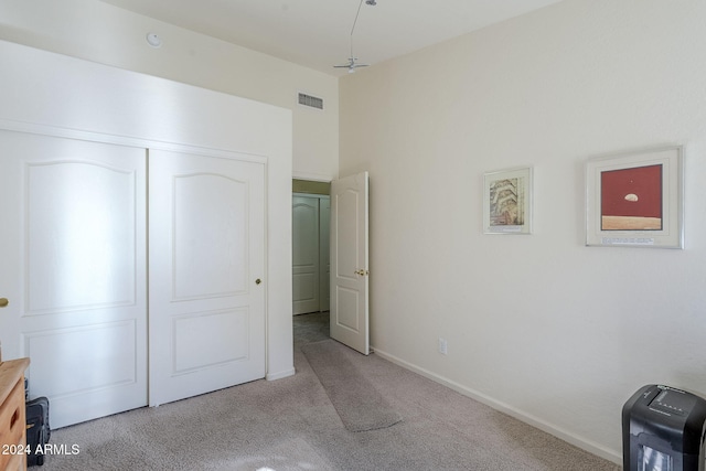 unfurnished bedroom featuring a closet and light carpet